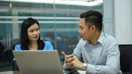 A man and a woman discussing in front of the laptop