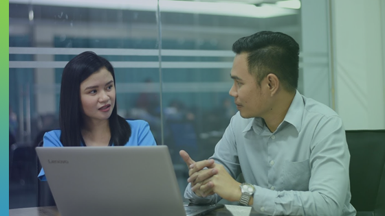 A man and a woman discussing in front of the laptop